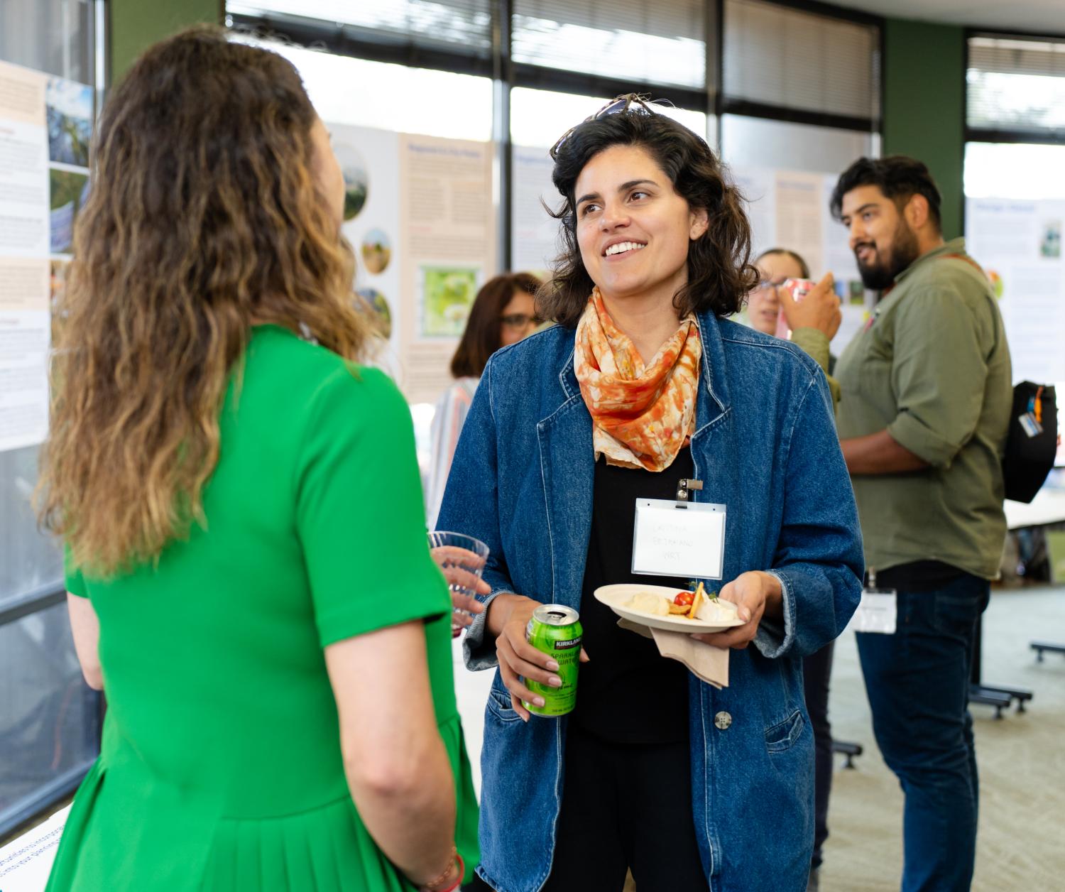 Small groups of people talk to each other at a professional gathering.