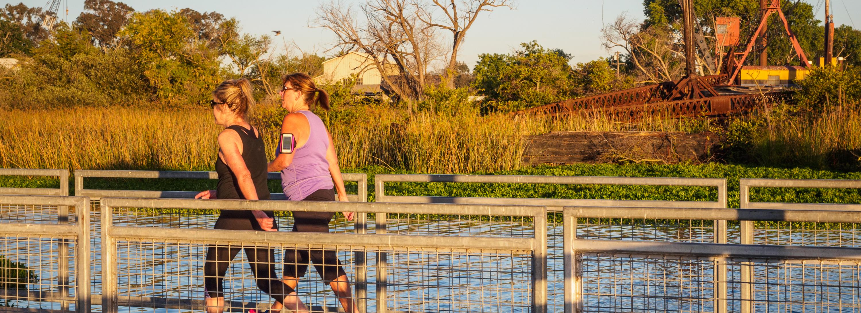 Two people walking near the water