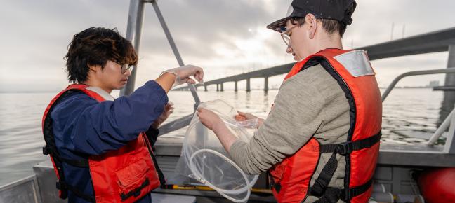 People sampling water on a boat
