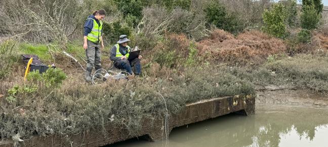 People sampling sediment