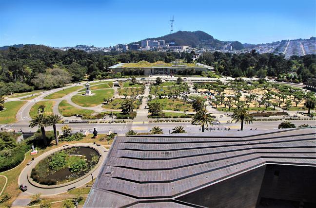 Aerial view of landscaping in front of the California Academy of Sciences, with San Francisco hills and Sutro Tower in the background
